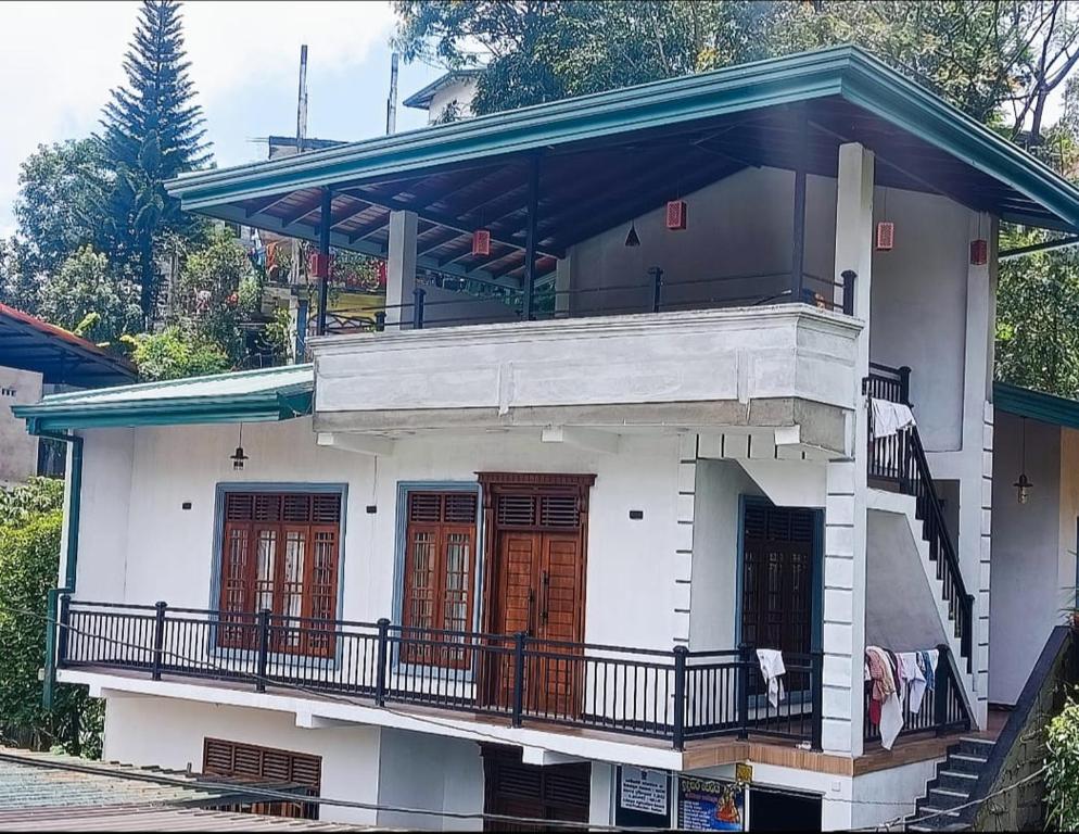 a white house with a balcony on top of it at Horizon Guest Hatton in Hatton