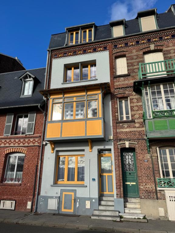 ein Backsteingebäude mit orangefarbenen Türen und Fenstern in der Unterkunft Villa Simone - 8 pers, 100m plage et sauna in Mers-les-Bains