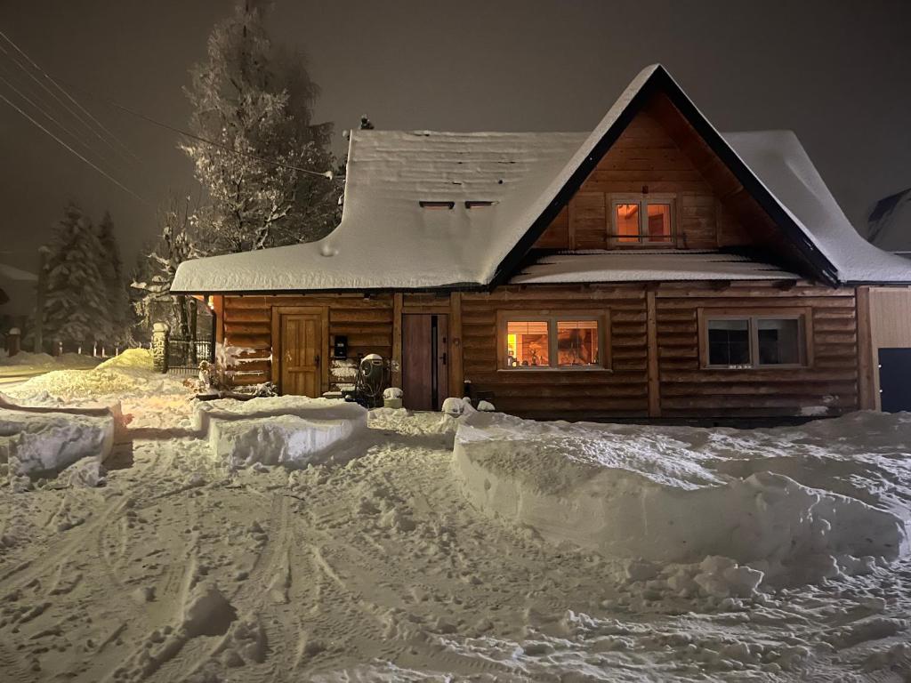 uma cabana de madeira na neve à noite em Sykowno Góralsko Chata em Zakopane