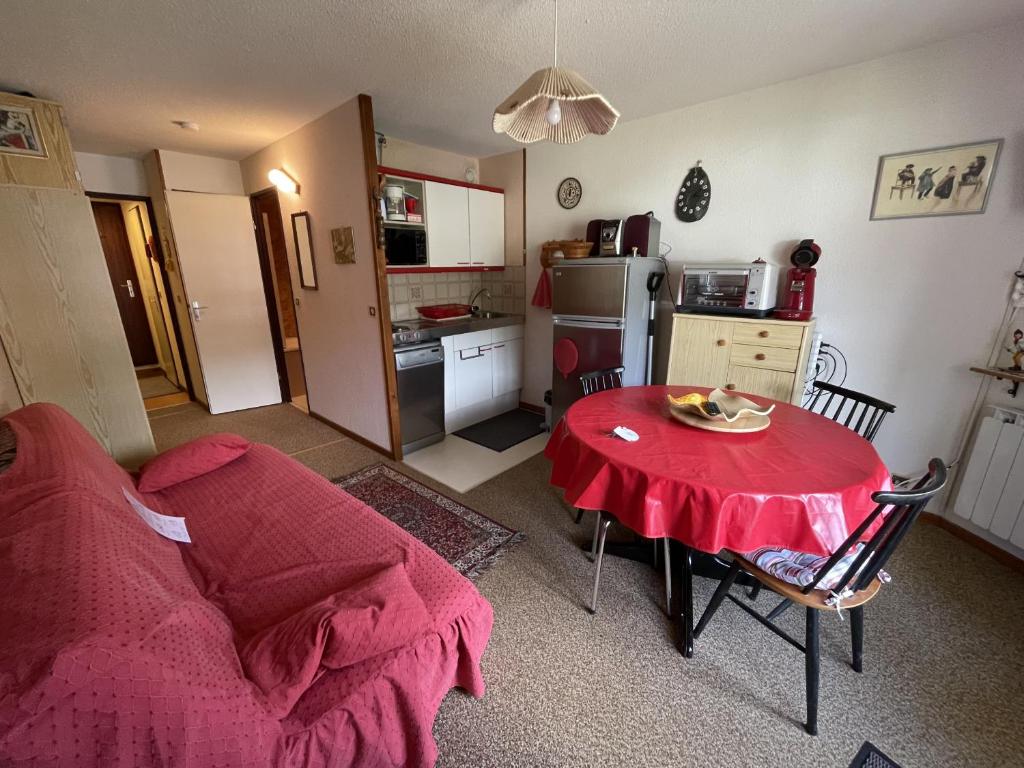 a living room with a table and a kitchen at Appartement 2 pièces Griou 52 in Le Lioran