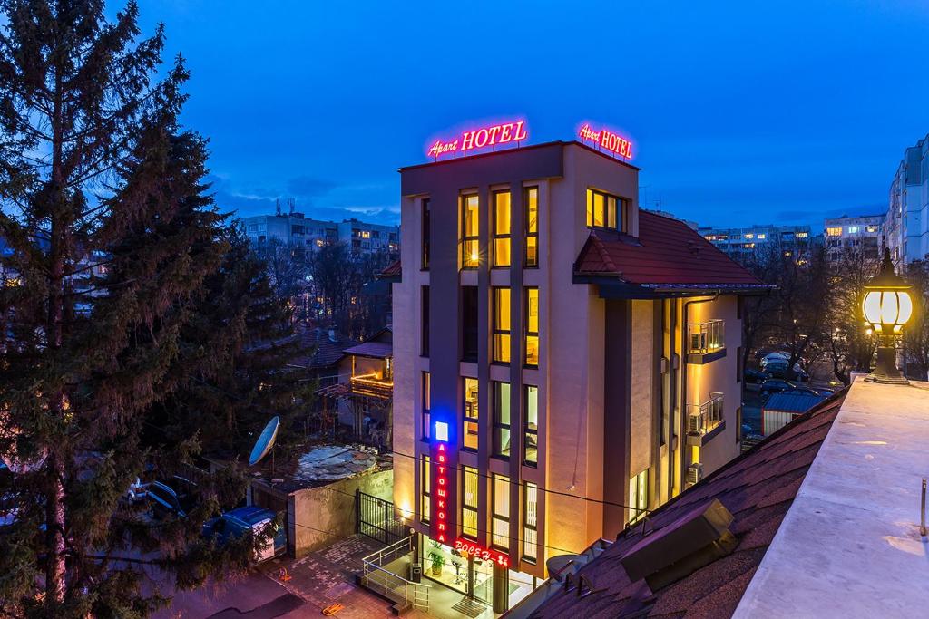 a building with a neon sign on top of it at Apart Hotel Rosen in Sofia