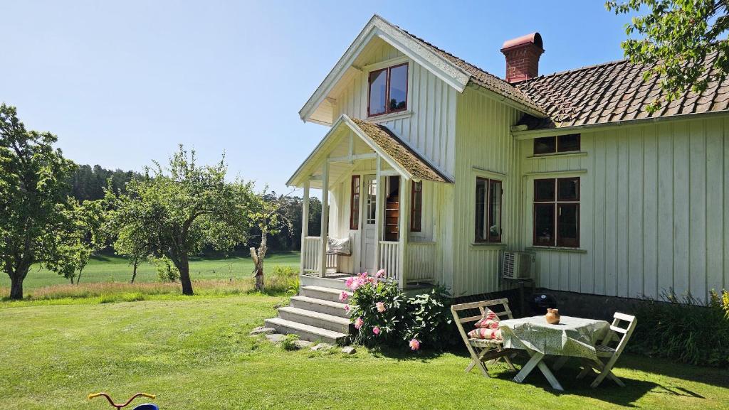 Charming house with kayaks, 300m from the sea on Orust SE09139 في Svineviken: منزل أخضر صغير مع طاولة وكراسي