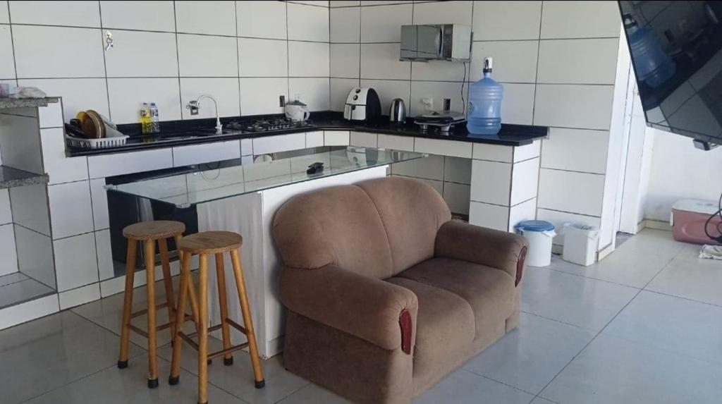 a kitchen with a chair and a sink and a counter at Casa em Itapucu SC a 200mts do trapiche in Araquari