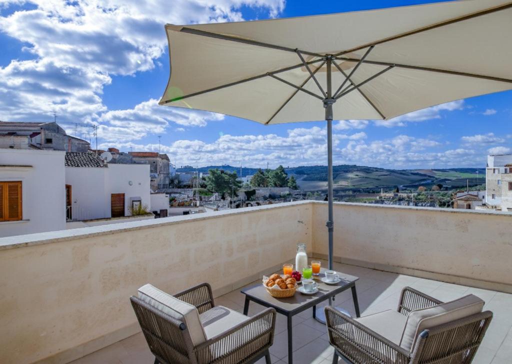 a patio with a table and an umbrella at Palazzo Fondo Vico - Affitti Brevi Italia in Gravina in Puglia