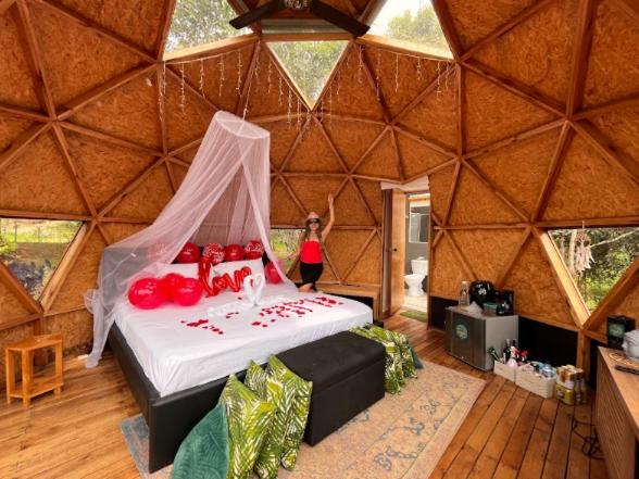 a woman standing in a yurt with a bed in it at Prana Hills in Estación El Salto