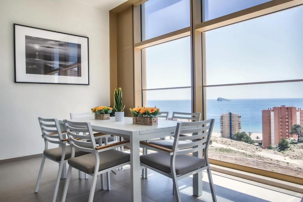 a dining room with a table and chairs with a view of the ocean at Intempo by Holuxe - 034 - 3rd floor in Benidorm