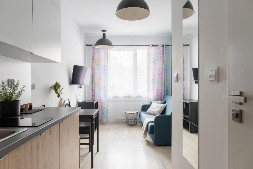 a kitchen and living room with a table and chairs at ADLER Room Suite in Łódź