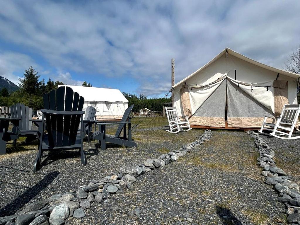 Cute and Comfortable Safari Tent in Seward, Alaska - Amazing Glamping Accommodation with Breathtaking Mountain Views في Bear Creek: خيمة مع كراسي وطاولة وكراسي