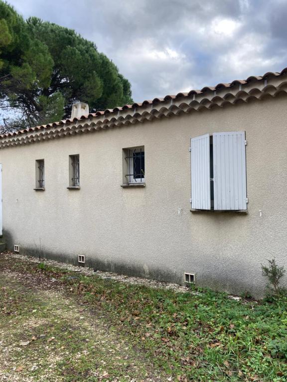un bâtiment avec trois fenêtres et un volet blanc dans l'établissement Maison de vacances et de paix, à Monteux
