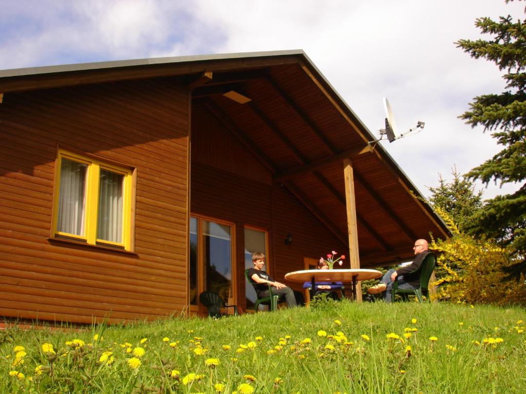 a group of people sitting in chairs outside of a house at Thomsdorf Sommerland in Thomsdorf