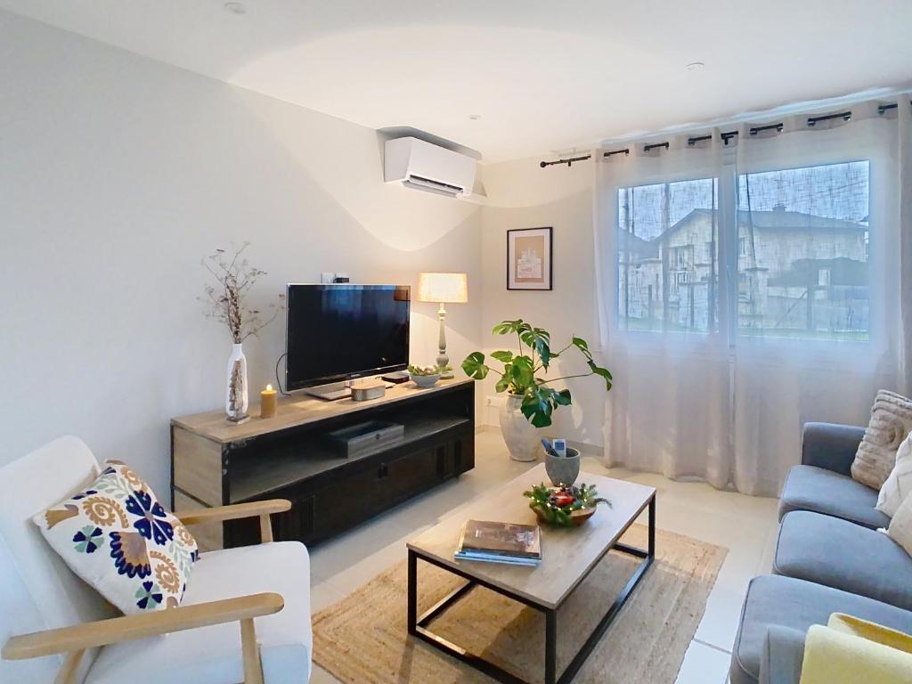 a living room with a tv and a couch at NUIT ET JOUR à Chaumont in Chaumont