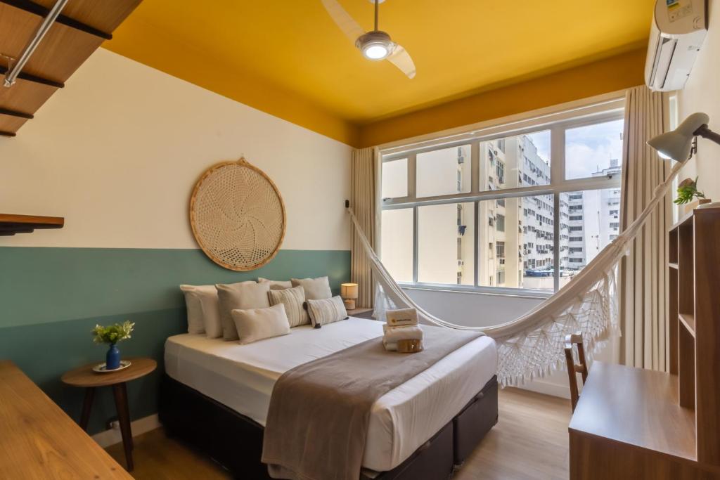 um quarto com uma cama e uma janela grande em 1 minuto da Praia de Copacabana - PF714 no Rio de Janeiro
