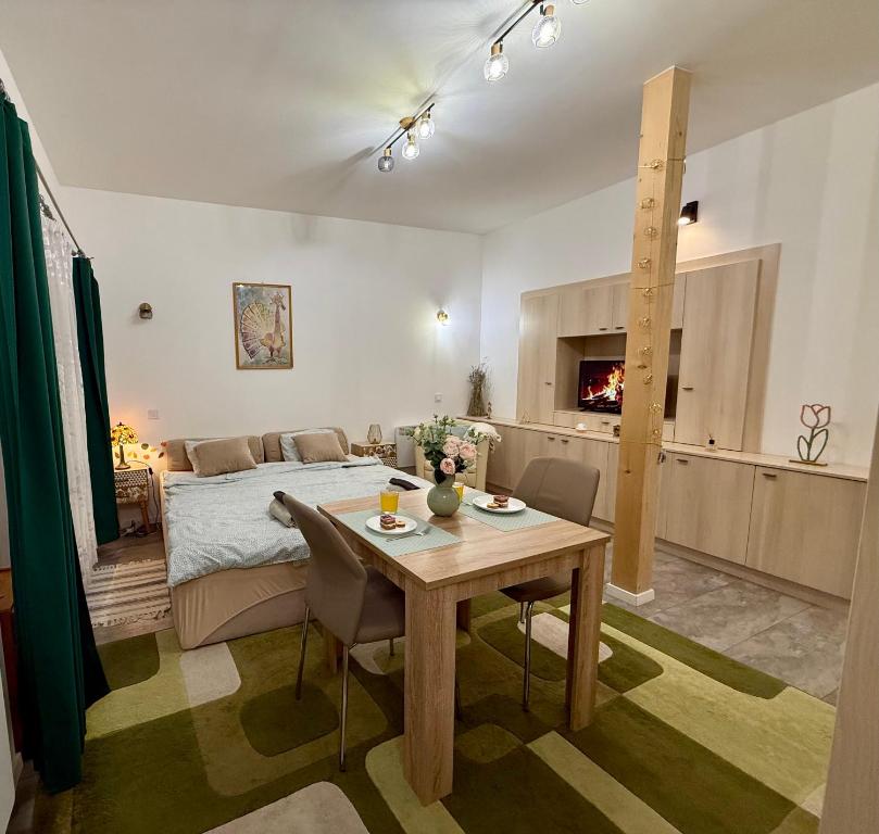 a room with a bed and a table with chairs at Infinity Apartman in Esztergom