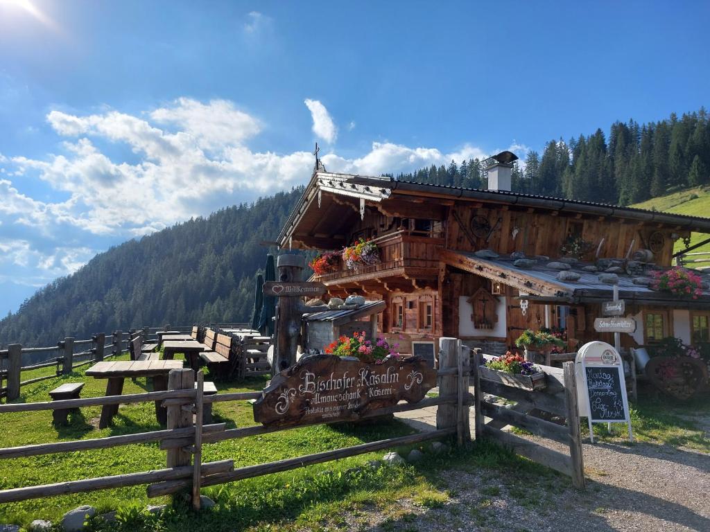 a small building in a field next to a fence at Ferienhütte Alpenherz in Alpbach