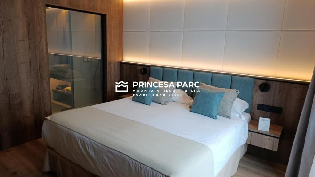 アリンサルにあるHotel Princesa Parc Excellenceの大きな白いベッドと青い枕のある寝室