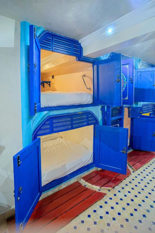 a blue bunk bed in a room with blue cabinets at Laghrib Hostel in Tangier