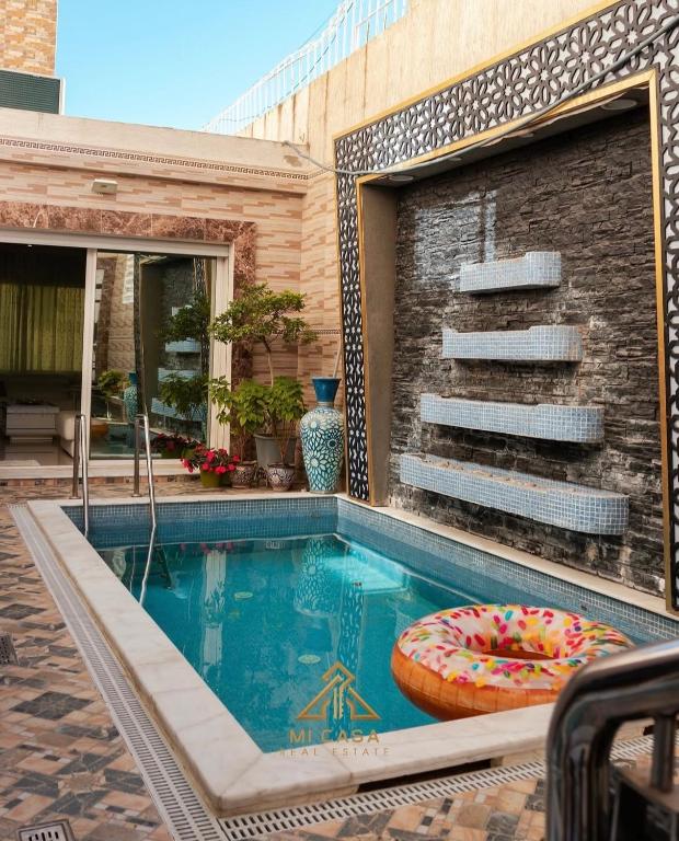 a swimming pool with a chair and a pillow in front of a building at Apartment Nazaha for families only in Tangier