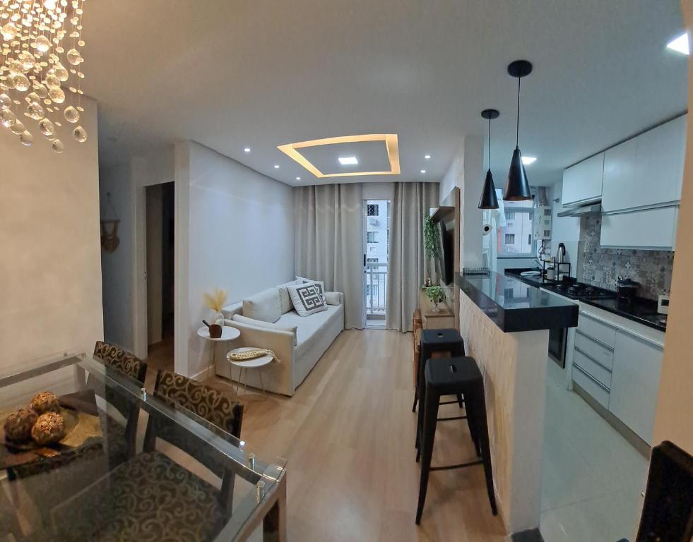 een keuken en woonkamer met een bank en een tafel bij Riocentro, Projac, Parque Olímpico, apartamento completo com vaga! in Rio de Janeiro