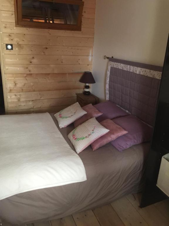 una camera da letto con un letto con cuscini rosa e bianchi di Maison La Minoterie a Volonne