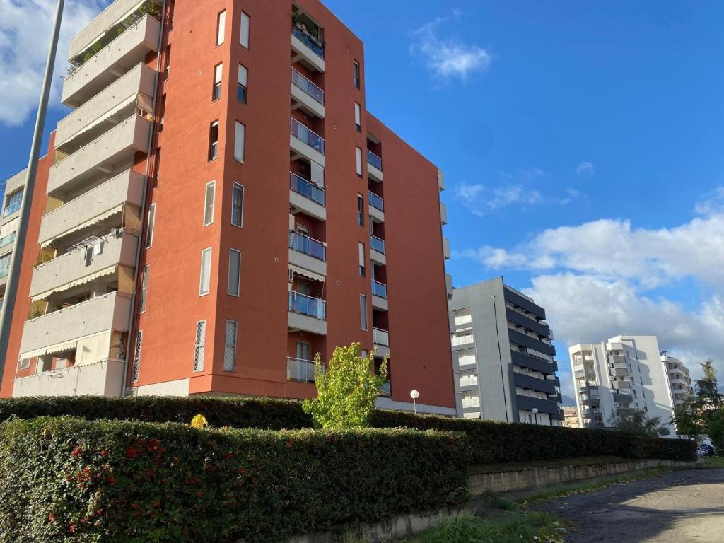 a tall red brick building next to some buildings at B&B Olimpia in Cosenza