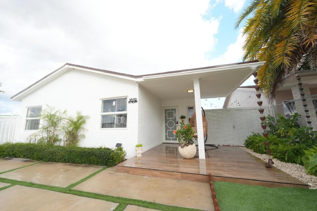 a white house with a wooden deck in front of it at E&A SouthWest Miami - Breeze Studio in Kendale Lakes