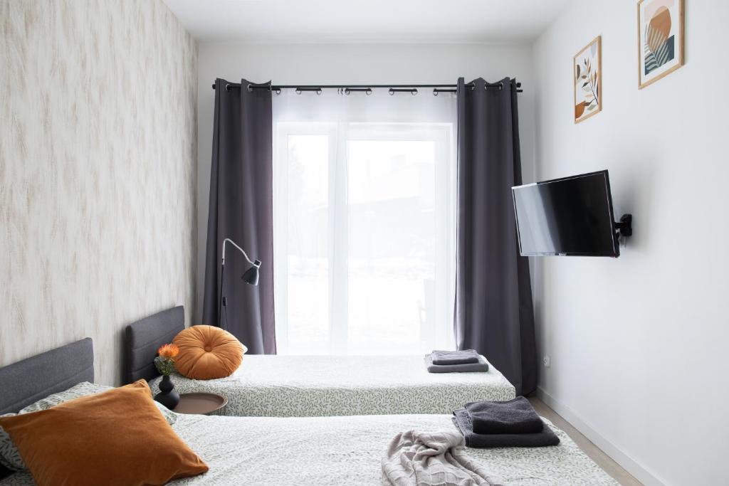 a bedroom with two beds and a window at ADLER Studio in Łódź