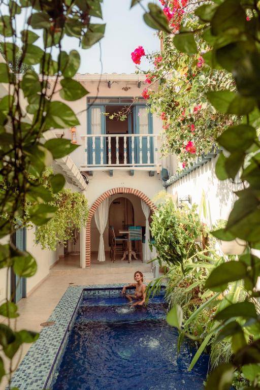 a man sitting in a pool in front of a house at Casa Heredia Boutique in Cartagena de Indias