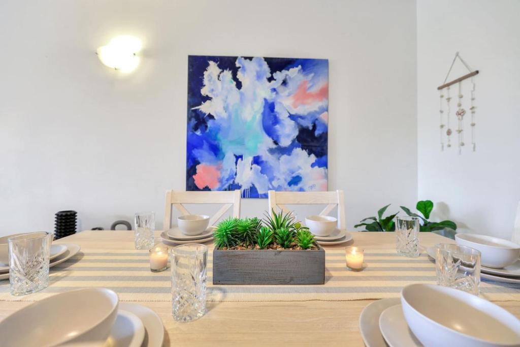 a table with plates and dishes on it with a painting at Style, Luxury and Comfort in Larrakeyah in Larrakeyah