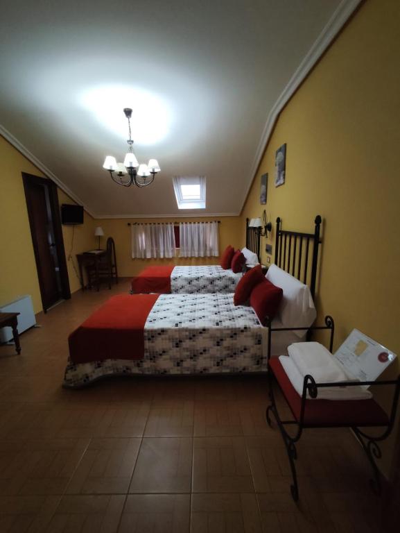 a large bedroom with two beds and a couch at Hostal Juan in Rosal