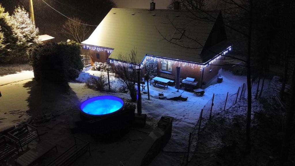 a house with a blue light in the snow at night at Chata pod Prašivou in Vyšní Lhoty