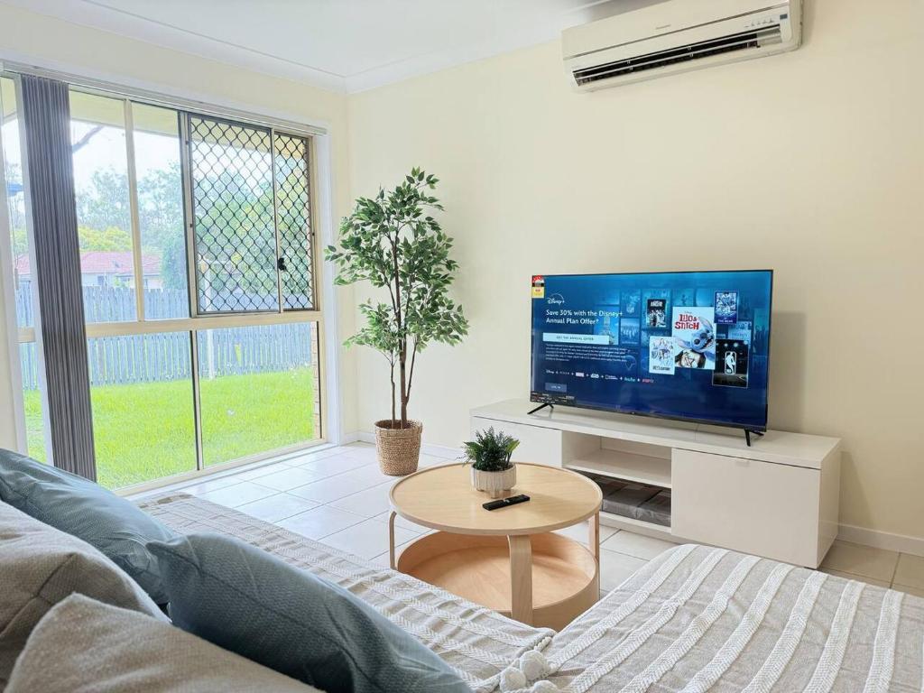 a living room with a large tv and a couch at Riverview Modern Haven in Riverview
