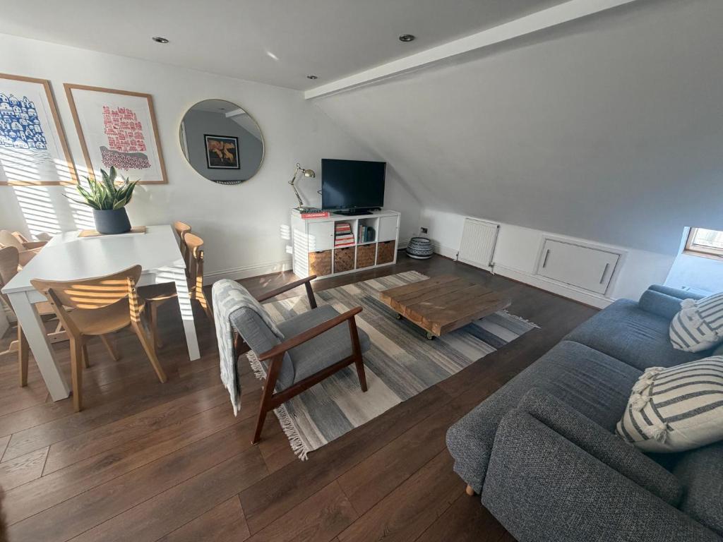 ein Wohnzimmer mit Sofa und Tisch in der Unterkunft Cozy and Convenient Raynes Park maisonette in Raynes Park