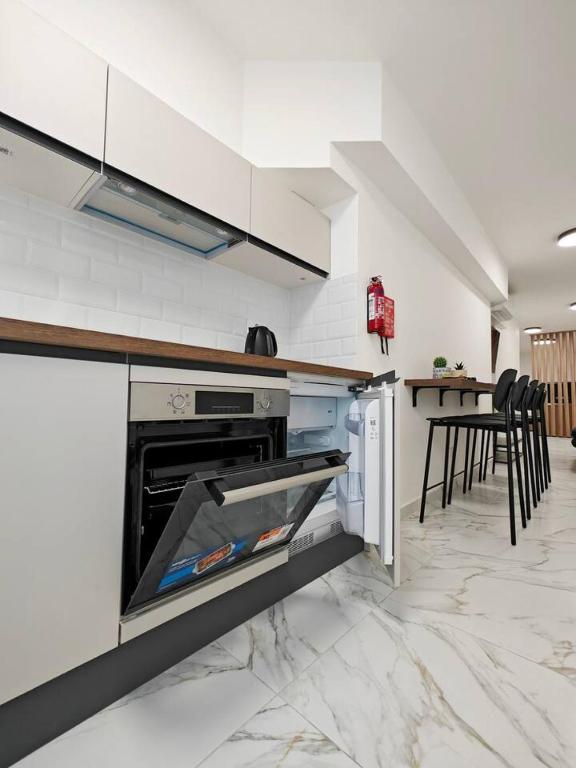 een keuken met een open oven, een tafel en stoelen bij Balluta Bliss in Il-Gżira