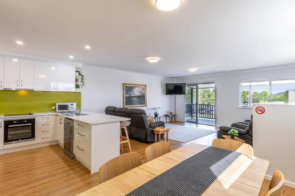 a kitchen and living room with a table and chairs at Central Chic- Beautifully appointed townhouse in Myrtleford