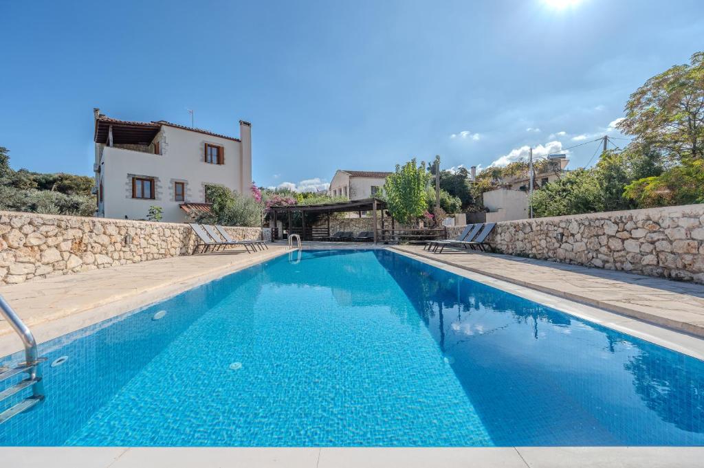 a swimming pool in a villa with a stone wall at Vamos villa in Vamos