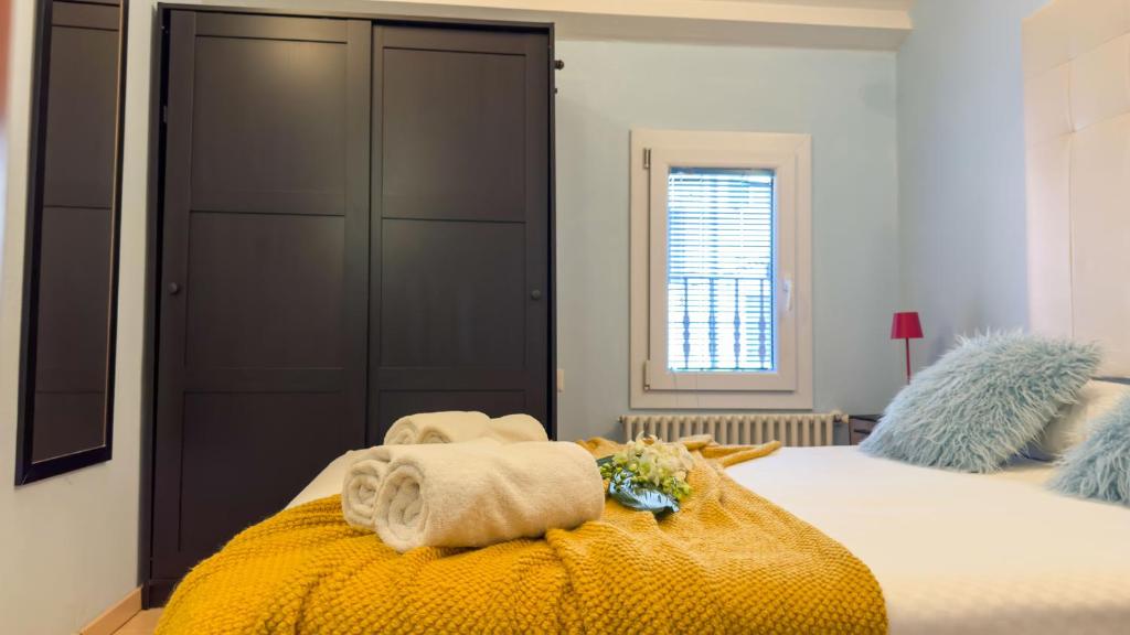 a bedroom with a bed with towels and a window at La Casa Gialla by Ca-Sa Check in Chioggia