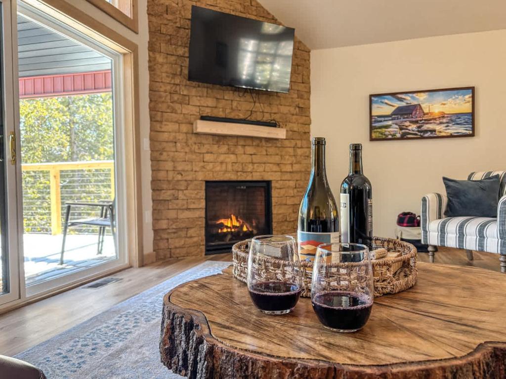 una stanza con un tavolo con bicchieri da vino e un camino di Spacious 4Br CavePoint Stay Near Dunes PetFriendly a Jacksonport