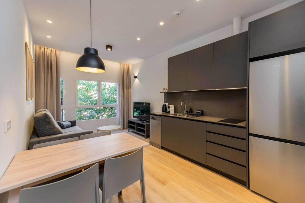 a kitchen with a table and a large refrigerator at Stancia Benimaclet - Studio 9 in Valencia