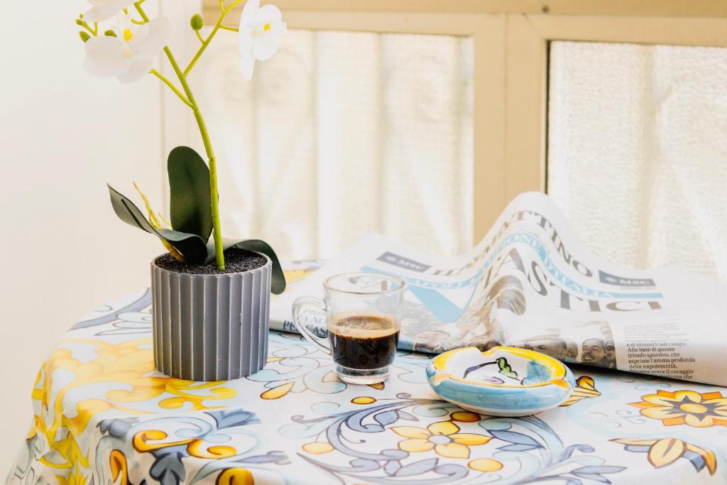 un tavolo con un vaso con un fiore sopra di Jordan Apartment a Napoli