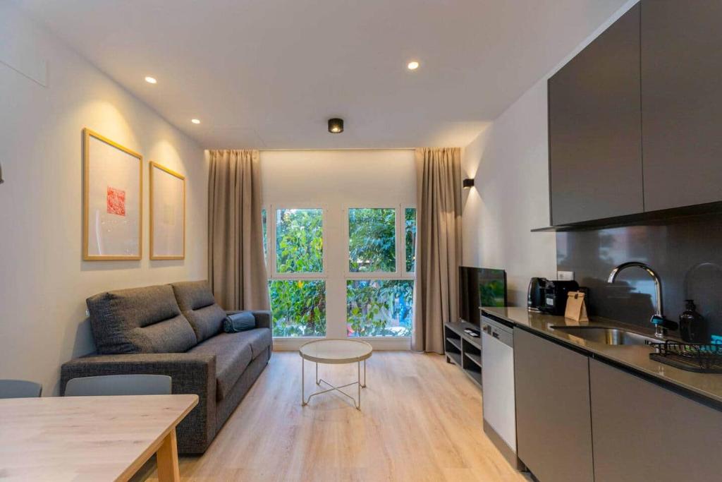 a kitchen and living room with a couch and a table at Stancia Benimaclet - Studio 1 in Valencia