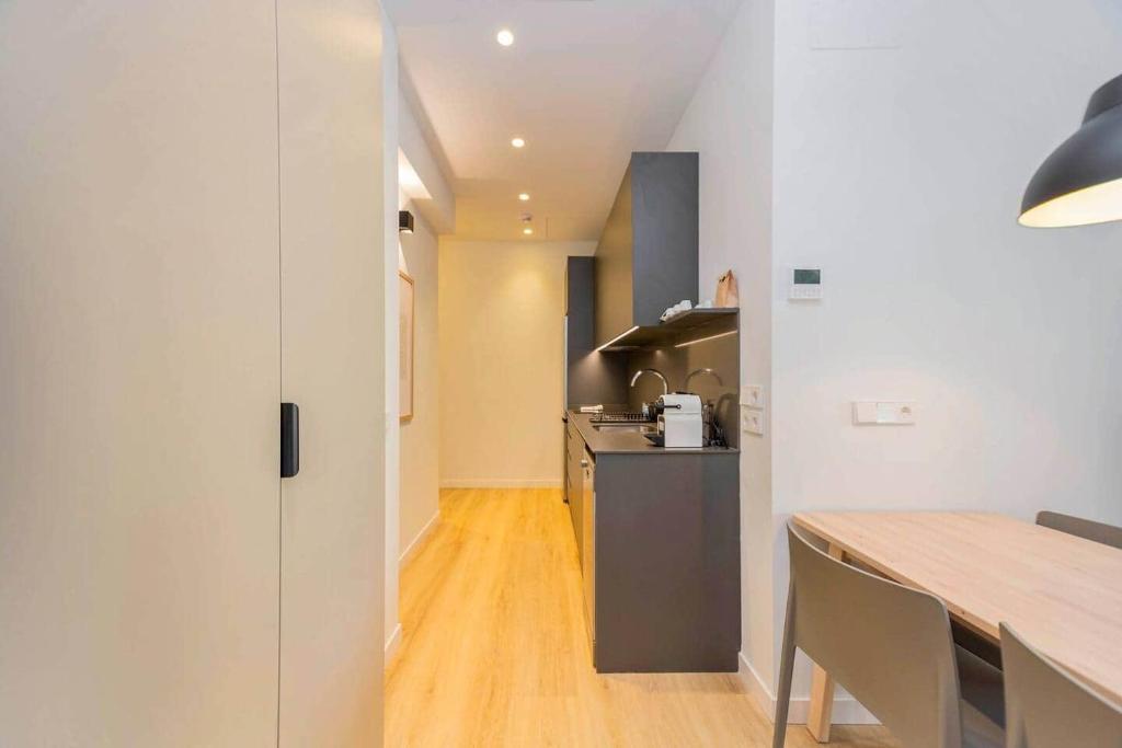 a kitchen with white walls and a wooden table at Stancia Benimaclet - Studio 11 in Valencia