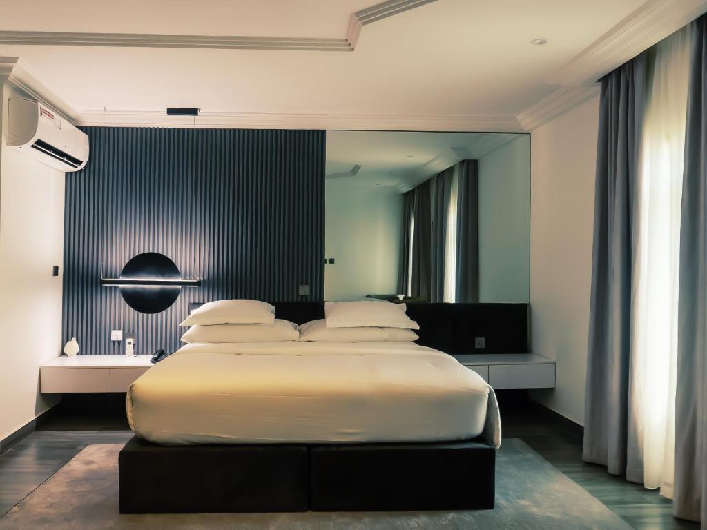 BamgboseにあるHiro Hotelの黒い壁のベッドルーム1室(大型ベッド1台付)