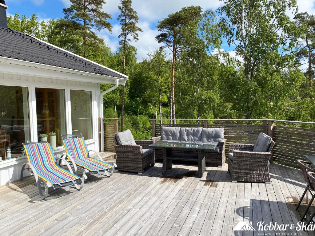 Villa with sauna, 650 m to the beach SE09135 في Sörtegen: فناء مع كراسي وطاولة على السطح