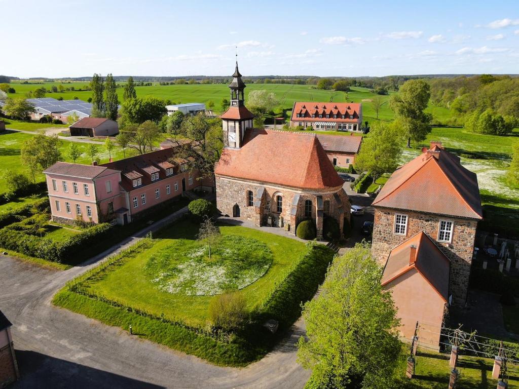 een luchtzicht op een oude kerk met een toren bij Hofensemble nahe Berlin in Lietzen
