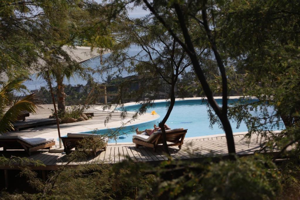 曼科拉的住宿－海洋美景度假屋，两人坐在游泳池旁的长椅上