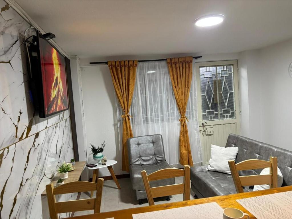 Apartamento cerca al aeropuerto في بوغوتا: غرفة معيشة مع أريكة وكرسي