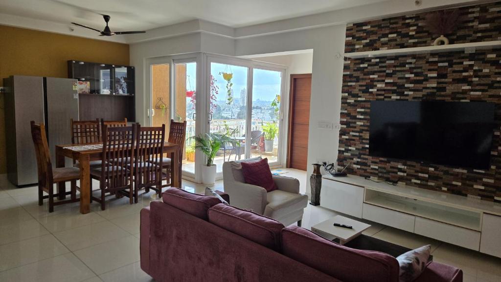 ein Wohnzimmer mit Sofa und Flachbildfernseher in der Unterkunft Hoysala Ace 1 in Bangalore
