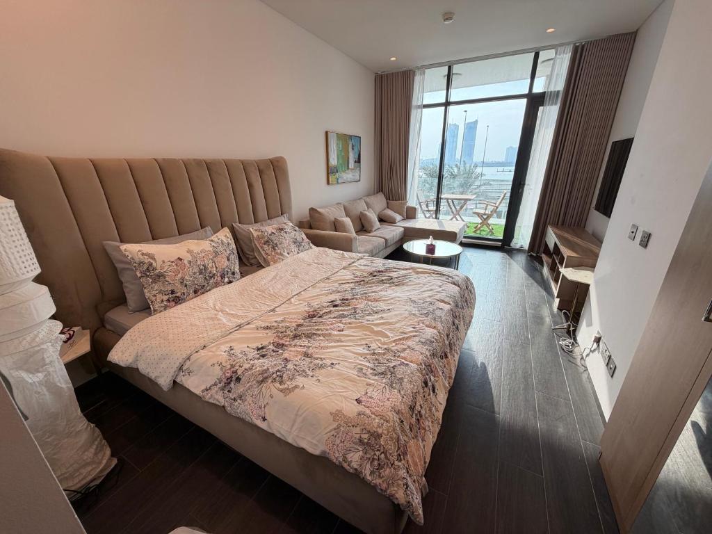 Un dormitorio con una cama grande y un sofá. en Sea View Studio Perfect for Couples In Harbour Row, en Manama