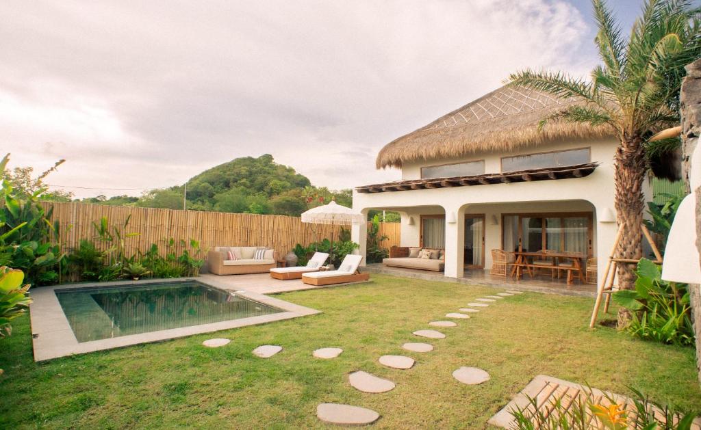 un cortile con piscina e una casa di Irama Surf Villas a Sekongkang Bawa