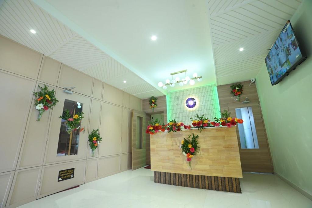 een lobby met bloemen aan de muur in een gebouw bij Umaa Sleeping Beds Dormitory in Pārvatīpuram